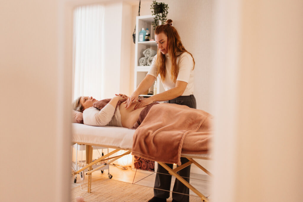Behandeling littekenmassage en keizersnede herstel door specialist met cliënt in massagepraktijk